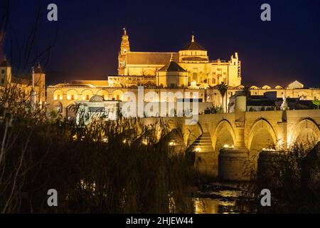 CORDOBA ANDALUCIA SPANIEN DIE BELEUCHTETE MOSCHEE KATHEDRALE MEZQUITA UND RÖMISCHE BRÜCKE ÜBER DEN GUADALQUIVIR FLUSS IN DER NACHT Stockfoto