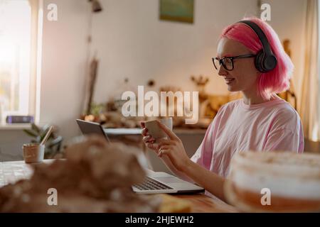 Junge und lächelnde Töpferin, die im Kunstatelie Geschäfte macht Stockfoto