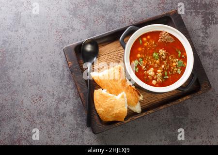Traditionelle Suppe Chorba Frik aus Lamm, Freekeh und Gemüse in Nahaufnahme auf einem Teller auf dem Tisch. Horizontale Draufsicht von oben Stockfoto