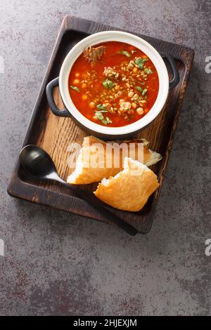 Chorba Frik ist eine zerkleinerte grüne Weizen- und Fleischsuppe, die in Algerien konsumiert wird, vor allem während des ramadan-Monats in Nahaufnahme auf einem Teller auf dem Tisch. Version Stockfoto