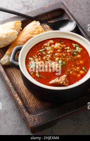 Chorba Frik ist eine zerkleinerte grüne Weizen- und Fleischsuppe, die in Algerien konsumiert wird, vor allem während des ramadan-Monats in Nahaufnahme auf einem Teller auf dem Tisch. Version Stockfoto