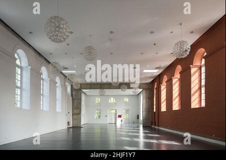 Putbus, 22. August 2021: Großer leerer Saal mit weißen und roten Wänden und Bogenfenstern, Veranstaltungsraum im Marstall von Putbus auf dem IS Stockfoto