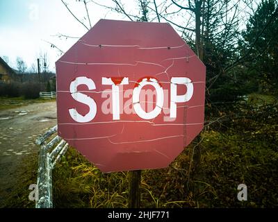 Verlassene alte Stoppschild auf der Landstraße Stockfoto