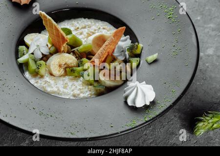 Quinoa-Haferbrei mit Banane, Heidelbeere und Pekannüssen zum Frühstück. Stockfoto