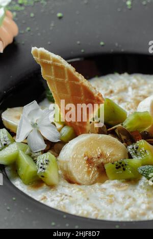 Quinoa-Haferbrei mit Banane, Heidelbeere und Pekannüssen zum Frühstück. Stockfoto