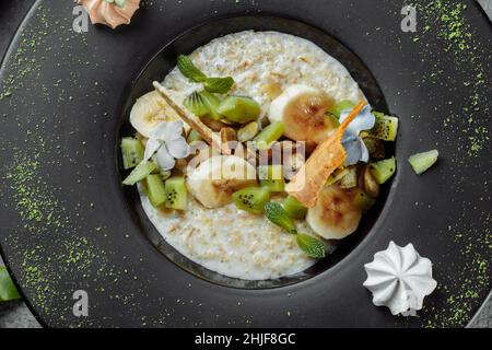 Quinoa-Haferbrei mit Banane, Heidelbeere und Pekannüssen zum Frühstück. Stockfoto