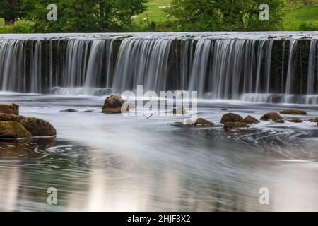 Sommer Blick auf Boston Spa Wehr auf dem Fluss Wharfe mit einem niedrigen Fluss von Wasser über dem Wehr Stockfoto