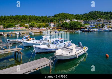 Limenas, Thassos, Griechenland - Fischerboote und Badestrand am Hafen von Limenas. Die Hauptstadt der Insel Thassos ist ein beliebtes Reiseziel für Vacas Stockfoto