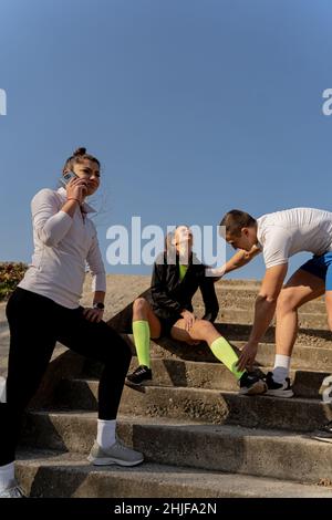 Zwei tolle und attraktive Freunde helfen ihr bei der Verletzung Stockfoto