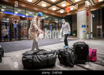 Yanqing, China. 29th Januar 2022. Hotelmitarbeiter desinfizieren das Gepäck der angereist Journalisten. Alle Teilnehmer der Olympischen Winterspiele 2022 müssen mit speziellen Charterflugzeugen anreisen und dürfen sich erst nach einem ausgiebigen proram-Test in einer „Blase“ bewegen. Die Unterkünfte sind durch Zäune vom Rest Chinas getrennt und nur spezielle Busse bringen sie zu den Wettkampfstätten. Die Freizügigkeit im ganzen Land ist nicht möglich. Quelle: Michael Kappeler/dpa/Alamy Live News Stockfoto