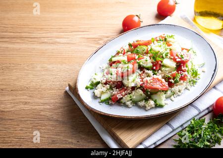 Traditionelle orientalische Salattabulei. Salat aus Cous Cous mit Gemüse. Tabbouleh mit Bulgur Stockfoto