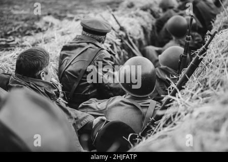 Re-enactors gekleidet als Russian Soviet Red Army Soldaten des Zweiten Weltkriegs versteckt sitzen in Graben. Foto In Schwarzweiß. 2. WELTKRIEG WW2 Stockfoto