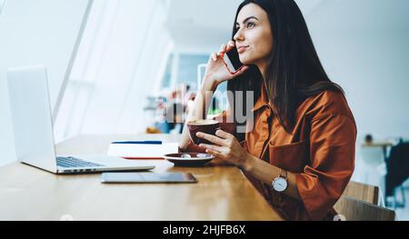 Dunkelhaarige Frau, die am Telefon spricht Stockfoto