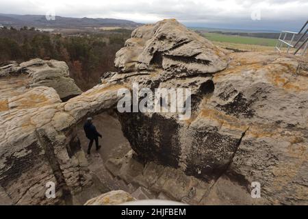 Blankenburg, Deutschland. 29th Januar 2022. Besucher genießen den Blick über den Harz auf Schloss Regenstein. Ein beliebtes Ziel ist der Sandsteinfelsen, auf dem einst die Höhlenburg stand. Dort können Sie die denkmalgeschützten Überreste der Burg Regenstein besichtigen, die 1169 erstmals erwähnt wurde. Vom 12th. Bis zum 15th. Jahrhundert war es der Machtsitz der Grafen von Regenstein. Als Besonderheit gelten die insgesamt 32 in Sandstein gehauenen Felssäle, von denen die meisten besichtigt werden können. Quelle: Matthias Bein/dpa-Zentralbild/ZB/dpa/Alamy Live News Stockfoto