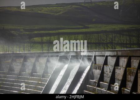 West Yorkshire, Großbritannien. 29th Januar 2022. Wetter in Großbritannien. BAITINGS Reservoir, Ripponden, West Yorkshire, Großbritannien. Sturm Maliks starker Wind peitscht das Wasser im Baitings Reservoir in der Nähe von Ripponden West Yorkshire und erzeugt große Wellen und einen Wassernebel durch die Staudämme. Der Nebel fängt das Sonnenlicht ein und erzeugt einen Regenbogen. Stockfoto