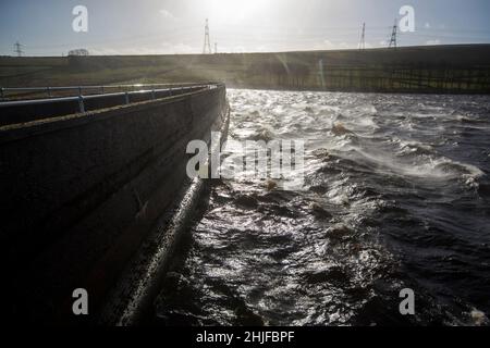 West Yorkshire, Großbritannien. 29th Januar 2022. Wetter in Großbritannien. BAITINGS Reservoir, Ripponden, West Yorkshire, Großbritannien. Sturm Maliks starker Wind peitscht das Wasser im Baitings Reservoir in der Nähe von Ripponden West Yorkshire und erzeugt große Wellen und einen Wassernebel durch die Staudämme. Der Nebel fängt das Sonnenlicht ein und erzeugt einen Regenbogen. Stockfoto
