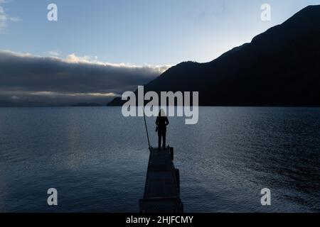 Petrohue, Los Lagos, Chile. 29th Januar 2022. Eine Frau beobachtet den Sonnenaufgang am Lake Todos Los Santos in Petrohue, Südchile. (Bild: © Matias Basualdo/ZUMA Press Wire) Stockfoto