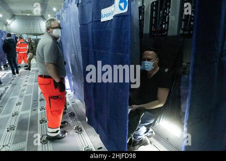 Calden, Deutschland. 29th Januar 2022. Helfer und medizinisches Personal stehen in einem Airbus A400 M der deutschen Luftwaffe, der sich auf dem Asphalt des Flughafens Kassel befindet, während einer Impfkampagne zur Eindämmung des Coronavirus. Die Impfaktion im Airbus ist eine Kooperation zwischen dem Flughafen Kassel, dem Johanniter Regionalverband Kurhessen und dem Lufttransportgeschwader 62 aus Wunstorf. Quelle: Swen Pförtner/dpa/Alamy Live News Stockfoto