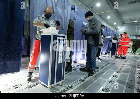 Calden, Deutschland. 29th Januar 2022. Helfer und medizinisches Personal stehen in einem Airbus A400 M der deutschen Luftwaffe, der sich auf dem Asphalt des Flughafens Kassel befindet, während einer Impfkampagne zur Eindämmung des Coronavirus. Die Impfaktion im Airbus ist eine Kooperation zwischen dem Flughafen Kassel, dem Johanniter Regionalverband Kurhessen und dem Lufttransportgeschwader 62 aus Wunstorf. Quelle: Swen Pförtner/dpa/Alamy Live News Stockfoto