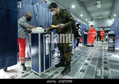 Calden, Deutschland. 29th Januar 2022. Helfer und medizinisches Personal stehen in einem Airbus A400 M der deutschen Luftwaffe, der sich auf dem Asphalt des Flughafens Kassel befindet, während einer Impfkampagne zur Eindämmung des Coronavirus. Die Impfaktion im Airbus ist eine Kooperation zwischen dem Flughafen Kassel, dem Johanniter Regionalverband Kurhessen und dem Lufttransportgeschwader 62 aus Wunstorf. Quelle: Swen Pförtner/dpa/Alamy Live News Stockfoto