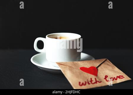 Tasse Espresso mit valentine. Schwarzer Hintergrund, selektiver Fokus. Stockfoto
