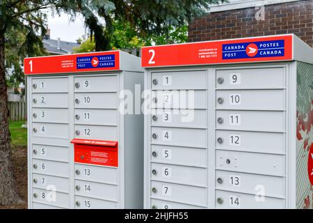 Ottawa, Kanada - 10. Oktober 2021: Canada Postfächer in der Nachbarschaft in der Nähe des Parks mit rotem Schild in Englisch und Französisch Stockfoto