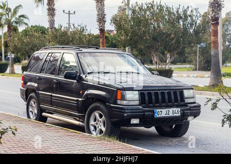 Side, Türkei - 18. Januar 2022: Black Jeep Grand Cherokee wird an einem warmen Sommertag auf der Straße vor dem Hintergrund eines Gebäudes, Stockfoto