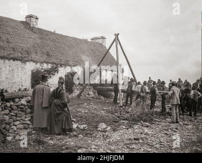 Ein Vintage-Foto der Räumung einer irischen Familie aus dem Jahr 1888 in Moyasta, Grafschaft Clare, in der ein Rammbock verwendet wurde. Vermieter, deren Land mit ärmeren Mietern überfüllt war, wurden jetzt mit hohen Tarifen konfrontiert und viele begannen, die armen Mieter von ihren kleinen Grundstücken zu räumen. Die große Masse an Zwangsräumungen kam im Jahr 1840s, und als die Polizei begann, eine Zählung zu halten, verzeichneten sie insgesamt fast 250.000 Personen, die zwischen 1849 und 1854 offiziell vertrieben wurden. Die Räumungen dauerten bis zum 1890s. Stockfoto