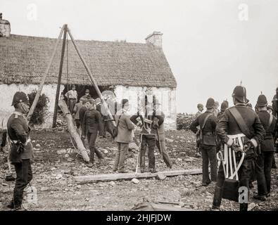 Ein Vintage-Foto der Räumung einer irischen Familie aus dem Jahr 1888 in Moyasta, Grafschaft Clare, in der ein Rammbock verwendet wurde. Vermieter, deren Land mit ärmeren Mietern überfüllt war, wurden jetzt mit hohen Tarifen konfrontiert und viele begannen, die armen Mieter von ihren kleinen Grundstücken zu räumen. Die große Masse an Zwangsräumungen kam im Jahr 1840s, und als die Polizei begann, eine Zählung zu halten, verzeichneten sie insgesamt fast 250.000 Personen, die zwischen 1849 und 1854 offiziell vertrieben wurden. Die Räumungen dauerten bis zum 1890s. Stockfoto