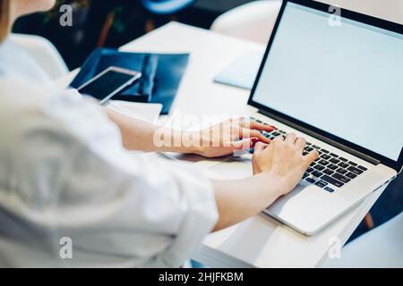 Frau, die während des Arbeitstages einen Laptop benutzt Stockfoto