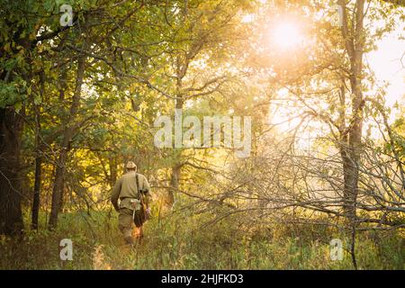 Re-enactor verkleidet als Soldat der russischen sowjetischen Roten Armee des Zweiten Weltkriegs, der mit Waffen durch den Herbstwald läuft. Soldat des Zweiten Weltkriegs WW2 Mal Stockfoto