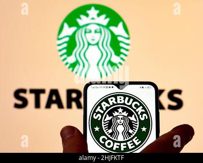 In dieser Abbildung ist das Starbucks Kaffee-Logo auf einem Smartphone-Bildschirm mit dem Starbucks Corporation-Logo im Hintergrund zu sehen. (Foto von Igor Golovniov / SOPA Images/Sipa USA) Stockfoto