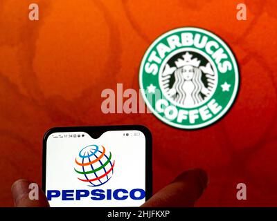 In dieser Abbildung ist das Logo von PepsiCo, Inc. Auf einem Smartphone-Bildschirm mit dem Starbucks Kaffee-Logo im Hintergrund zu sehen. (Foto von Igor Golovniov / SOPA Images/Sipa USA) Stockfoto