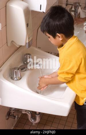 Bildung Vorschule im Alter von 4-5 Jahren Junge seine Hände waschen am Waschbecken im Badezimmer Stockfoto