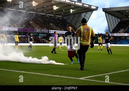 The Den, Millwall, London, Großbritannien. 29th Januar 2022. Championship Football, Millwall gegen West Bromwich Albion: Ein 2nd Rauch-Flair, das von den West Bromwich Albion-Fans auf den Platz geworfen wird, während Murray Wallace von Millwall auf den Platz schaut und ein Mitglied der Feuerwehr versucht, es zu löschen Credit: Action Plus Sports/Alamy Live News Stockfoto