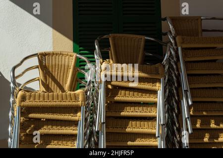 Stühle gestapelt auf der Terrasse eines typischen Restaurants auf der Insel Mallorca. Bild des Restaurants, das in der Nebensaison geschlossen wird Stockfoto