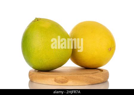 Zwei saftige süße Pomelos auf einem Holztablett, Makro, isoliert auf Weiß. Stockfoto