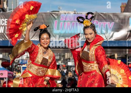 Chinesisches Neujahr 2022, Lunar New Year celebration Event in der High Street, Southend on Sea, Essex, Großbritannien Stelzer Wanderer in traditionellen hellen Kostümen Stockfoto