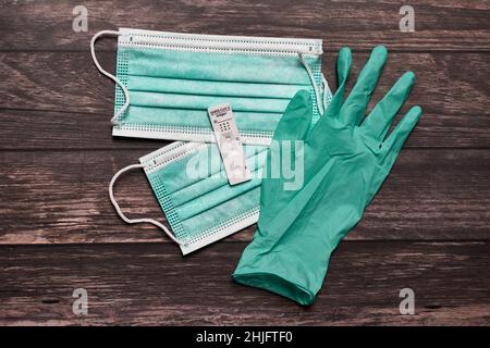 Gesichtsmasken, Handschuh und schneller Antigen-Selbsttest auf Coronavirus zeigen negative Ergebnisse Stockfoto