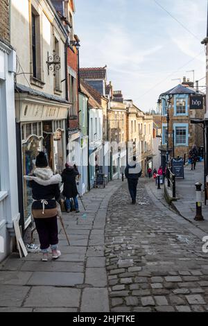 Künstler malen Catherine Hill / St. Catherines malerische gepflasterte Straße voller unabhängiger Geschäfte im Januar, Frome, Somerset, England, Großbritannien Stockfoto