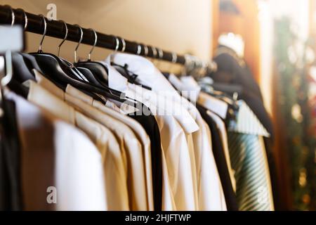 Kleidung hängt auf einem Regal im Bekleidungsgeschäft. Kleidung für Frauen hängen an Kleiderbügeln im Schrank oder Einkaufszentrum für den Verkauf von Geschäften Konzept. Stockfoto