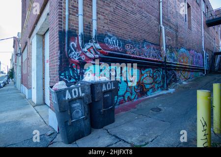 Mülltonnen sitzen in einer leeren Gasse in Winston-Salem. Stockfoto