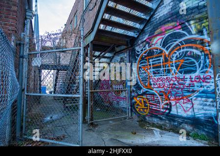 Graffiti und ein Kettenzaun in einer Winston-Salem-Gasse Stockfoto