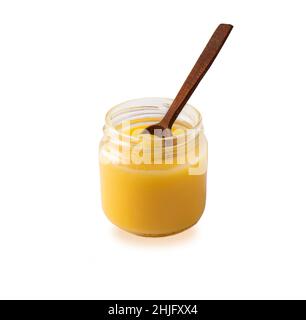 Ghee oder Butterreinfett im Glas, Speiseöl, reines Ghee isoliert auf weißem Hintergrund. Glas und Messung Holzlöffel Ghee - Butter aus Holz geklärt Stockfoto