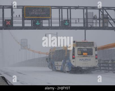 Halifax, Nova Scotia, Kanada. Januar 2022. Transit Bus 320, in reduziertem Verkehr auf der MacDonald-Brücke nach Halifax mit fast Null Sicht während eines Winterschneestürms Stockfoto