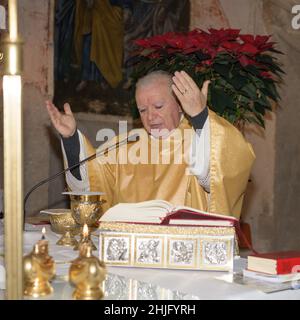 SAN PIETRO, ITALIEN - DICEMBRE, 26, 2021. Katholischer Priester, der die Feier des Sakraments der Eucharistie vorbereitet, liest die heilige bibel oder das Gebetsbuch durin Stockfoto