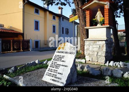 San Martino del Carso : der Stein mit den Linien des Dichters Giuseppe Ungaretti. Ungaretti wurde als "Anarchist" in die Polizeiakten aufgenommen, was ihn daran hinderte, Zugang zu den Schulungen für Offiziere zu erhalten. Er lebte im Graben als Privatperson, unter den Freibeutern, weg von der leeren, mitleidsbemitleidsenden Rhetorik der Offiziere. Er beschrieb dieses Leben als die „tägliche Häufigkeit des Todes“. Stockfoto