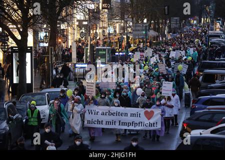 Düsseldorf, Deutschland. 29th Januar 2022. Mehrere tausend Menschen demonstrieren gegen staatliche Maßnahmen zur Eindämmung der Corona-Pandemie und gehen mit einem Transparent die Königsallee hinunter mit der Aufschrift: „Wir arbeiten mit Herz, nicht mit Impfpflicht“. Kredit: David Young/dpa/Alamy Live Nachrichten Stockfoto