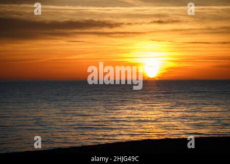 Ruhiges ionisches Meer mit Sonnenuntergang Himmel und Sonne durch die Wolken über in Apulien, Italien. Meditation Meer und Himmel Hintergrund. Ruhige Meereslandschaft mit Horizont ov Stockfoto