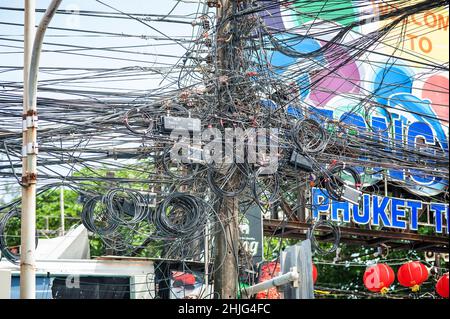 PHUKET, THAILAND - 11. MÄRZ 2018. Lampenpfosten auf Gewirr von elektrischen Drähten Hintergrund. Redaktionelle Tagesaufnahme Stockfoto